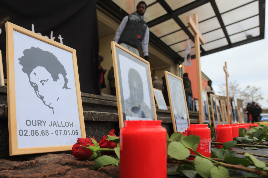 Jalloh-Ermittlungen bleiben eingestellt - kein Hinweis auf Mord - n einem Bild des Asylbewerbers Oury Jalloh (l) sind vor Beginn einer Demonstration zu seinem zehnten Todestag 2015 Blumen und Kerzen aufgestellt.