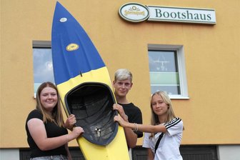 Jugend aus Geringswalde holt Kids vom Sofa - Lotta Fischer, Martin Reif und Tessa Wagenbichler (v. l.) haben fürs Foto schon mal eines der Kanus zum Anschauen aus dem Bootshaus geholt.