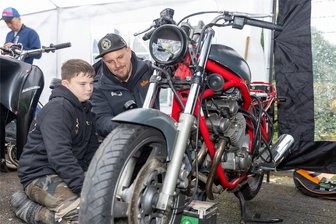 Jugend-Kultur-Festival in Auerbach: Kunterbuntes Konzept, gute Laune, wenige Besucher - Tipps vom „Schrauber“: Damian Schmidt (11) bekommt vom Patrick Böhm gezeigt, wie die Fehlersuche am Motorrad funktioniert.