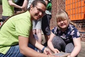Jung und Alt feiern Bergbautradition - Tamar Klötzer (l.) vom ortsansässigen Kita-Verein erklärt der achtjährigen Luna das Papierschöpfen