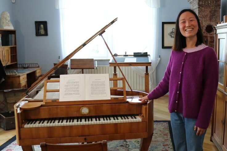 Junge Chinesin glücklich an Clara Schuhmanns Flügel - Pianistin Xinhui Wang vor Clara Schumanns Flügel. 