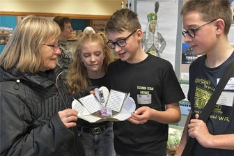 Junge Forscher in Brand-Erbisdorf: Bergbau als Klassenthema - In der Ausstellung erklärten Patrice Riediger (2. v. r.), Lena Griesbach und Martin Hopp (r.) seiner Oma Inge Wenzel (l.) eine Anschauungsbox mit geschichtlichen Themen.