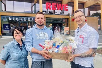 Junger Erzgebirger stoppt Diebesduo – Rewe-Team aus Lauter sagt danke - Ein Präsentkorb als Dankeschön: Filialleiter Maik Witte (r.) und Mitarbeiterin Simone Parthey mit Robin Wittig. Der 28-Jährige hatte dank seines beherzten Eingreifens auf dem Parkplatz des Rewe-Markts in Lauter ein Diebesduo gestoppt.