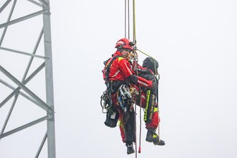 Junger Mann klettert auf Funkturm und bekommt Panik: Spezialeinheit der Feuerwehr trainiert im Erzgebirge Ernstfall - Florian Jahr seilt sich mit dem Dummy vom 54 Meter hohen Funkmast ab.