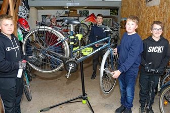 Jungs schrauben für Mädchen in Afrika - Paul Ullmann, Fred Thümmler, Niklas Zimmermann und Jonah Virginas (von links) helfen bei der Reparatur von Rädern. Pfarrer Andreas Virginas (im Hintergrund) hat ein Auge drauf.