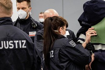 Juwelendiebstahl aus dem Grünen Gewölbe: Sechs Clan-Mitglieder vor Gericht - Einige der sechs Angeklagten aus dem arabischstämmigen Clan versteckten auf dem Weg in den Gerichtssaal die Gesichter hinter Aktendeckeln. Nicht so Mohamed R., der zusammen mit Wissam R. im Grünen Gewölbe die Axt geschwungen haben soll. Er grüßte Freunde im Zuschauerraum. 
