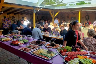 Kaffeegeruch statt Kirchenglocken: Warum beim Dorffrühstück in Mannichswalde 130 Plätze nicht reichen - Im Laubengang in Mannichswalde können die Gäste an den Tischen Platz nehmen und sich stärken.