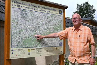 Kalender-Sammlung in Elterlein zeigt 230 Kirchen - Vor der Kirche steht die neue Infotafel zum Jakobsweg. Ullrich Kästli zeigt den Standort Elterlein.
