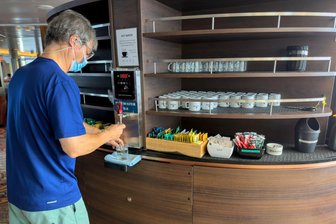 Kann sich das Virus vom Kreuzfahrtschiff weiter ausbreiten? - Ein Passagier auf dem vom Hantavirus betroffenen Kreuzfahrtschiff bedient sich während der Fahrt nach Teneriffa mit Wasser.