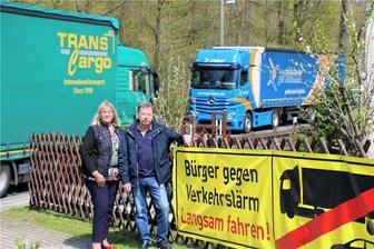 Kaputte Straße sorgt für Unmut in Herold - Sabine Schubert und Jürgen Pfoh vor einem der Plakate, auf denen um eine langsamere Fahrweise gebeten wird. 