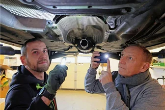 Katalysatoren-Diebstahl am Bowling-Pub in Glauchau: Kleine Edelmetalle für Diebe und großer Ärger für Autobesitzer - Hier fehlt der Katalysator: KfZ-Mechaniker David Sander (links) und Ralph Köhler werfen in der Werkstatt "Werk 3" in Zwickau-Crossen einen Blick unter den Wagenboden.