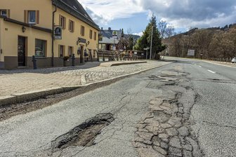 Keine Sanierung in Sicht: Drei desolate Staatsstraßen im Erzgebirge sorgen für Frust - Die tiefen Schlaglöcher in Erla vor der Gaststätte Eisenhütte und dem Herrenhof sollen demnächst „geflickt“ werden.