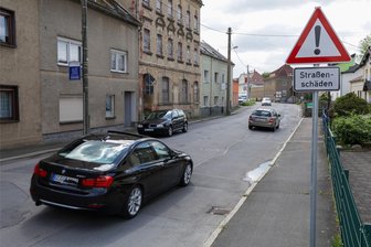 Keine Termine für Stadtring-Ausbau in Glauchau: Warum OB Steinhart zum Baubeginn schweigt - Blick zur Wehrstraße in Glauchau. Tausende Autos rollen täglich über den Stadtring-Abschnitt und damit vorbei an den Schildern, die vor Straßenschäden warnen.