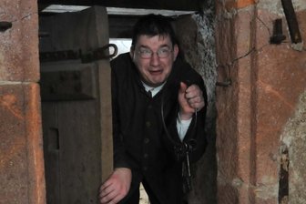 Kerkermeister führt durch Schlossgemäuer -