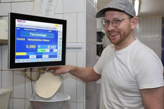 KI in der Backstube: Künstliche Intelligenz und Handwerk im Erzgebirge - Bäckermeister Tobias Nönnig an seiner computergesteuerten Waage, die er mit Daten aus dem Verkaufsprogramm füttert.