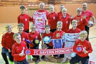 Kicken für den guten Zweck - Die Spieler und Betreuer des ESV Lok Chemnitz freuen sich auf das Turnier am Samstag. Hier zeigen sie einige der Fanartikel, die es dabei zugunsten des Elternvereins krebskranker Kinder zu ersteigern gibt.