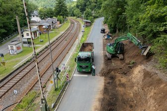 Kilometerlange Umwege durch Straßensperrung im Vogtland: Warum am Bahnübergang Barthmühle nicht bereits während der zweijährigen Brückensperrung gebaut wurde - Rechtsseitig der Bergstraße Richtung Jocketa entsteht eine 46 Meter lange Stützmauer, die im Berg verankert wird. Der Wanderweg oberhalb des Hanges ist jetzt nicht mehr passierbar.