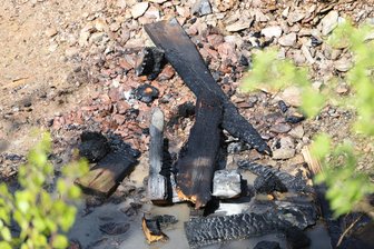Kinder entdecken Brand im Erzgebirge: Löschversuch mit Kaugummi-Bechern - Verkohlte Holzreste zeugen vom Brandgeschehen.