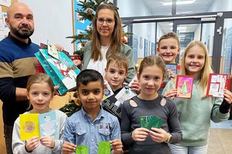 Kinder schicken Patienten im Krankenhaus Freiberg Weihnachtskarten: „Gute Besserung, Ihr Gustav aus der Körnerschule“ - Stellvertretend für die gesamte Grundschule Theodor Körner übergab Schulleiter Timo Trommler Weihnachtskarten, Rätsel und Gedichte an Claudia Steinbach vom Kreiskrankenhaus Freiberg. Unterstützt wurde er von den Schülerinnen und Schülern Gustav, Arav, Tim, Melina, Phil und Ella (v.l.).