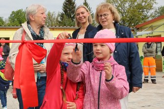Kinder schneiden stolz das Band durch: Neuer Außenbereich der Kita in Mühltroff eingeweiht - Johanna und Lara durften das symbolische rote Band zur Einweihung durchschneiden.