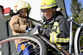 Kinder üben Ernstfall im Erzgebirge: Wenn Fünfjährige zur Rettungsschere greifen - Ferdinand Süß wird von Kevin Schmuck von der Feuerwehr Schneeberg angeleitet.