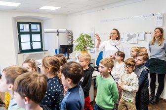 Kinder zu Besuch bei der „Freien Presse“ in Freiberg: So arbeitet die Redaktion - Kinder vom Hort „Spielhaus" in Freiberg besuchen die Redaktion der „Freien Presse" in Freiberg und lassen sich von Reporterin Cornelia Schönberg die Abläufe erklären. Erzieherin Mandy Siegert hört zu.
