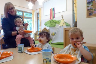 Kinderbetreuung: Eltern in Hartmannsdorf müssen sich ab Oktober auf höhere Kita-Beiträge für Krippenplätze einstellen - Kita-Alltag: Ida, Kurt und Emilio (v. links) sind mit dem Essen beschäftigt. Erzieherin Nadja Müller betreut sie.