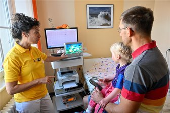 Kinderklinik Chemnitz: Mit einem Loch im Herzen geboren - Wie betroffene Kinder behandelt werden - Schwester Kathrin Strobel misst bei Rosa den Blutdruck. Um die Dreijährige abzulenken, flimmern Fische über einen extra Bildschirm.