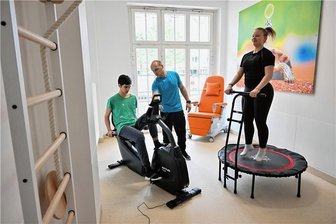 Kinderklinik Chemnitz: Wie Sport kleinen Patienten bei der Genesung helfen kann - Training mit Sporttherapeut Andreas Grünewald in der Kinderklinik des Klinikums. Borys radelt auf dem Ergometer, Marylou trainiert auf dem Trampolin.