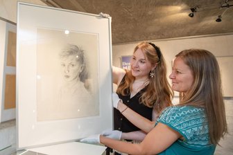 Kindheit im Bild: Neue Kabinettausstellung im Plauener Erich-Ohser-Haus - Mitarbeiterin Tanja Müller (rechts) und Interimsgaleristin Sarah Kühnel in der Ausstellung.