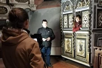 Kirche nimmt Gläubige digital mit - Sophie Kretzschmar moderiert aus einem evangelischen Beichtstuhl heraus, der in der Tragnitzer Kirche steht. Hinter der Kamera links steht Elias Bixl, Regie führt Michal Kreskowsky.