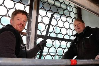 Kirchenfenster nun dicht - Reik Buhlig (r.) und David Zimmermann beim Einbau der sanierten, historischen Glasfenster in St. Georgen.