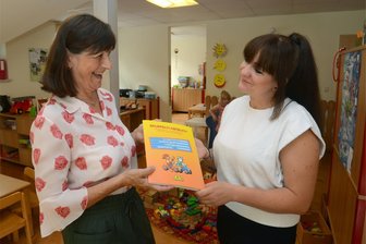 Kitaleiterin in Falkenstein geht in den Ruhestand - „Lauterbacher Strolche“ bereit für neues Oberhaupt - Die Arbeit bei den Strolchen kann und soll auch Spaß machen. Leiterin Gabriele Ernst (links) übergibt das Gruppentagebuch an ihre Nachfolgerin Anja Brunner.