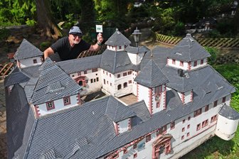 Klein-Erzgebirge: Darum sind die Stunden für die Augustusburg gezählt - Die Augustusburg ist bereits vom Schellenberg heruntergehoben worden, wartet auf ihren Abtransport. Oliver Weinhold zeigt noch einmal die Modellnummer des Objektes im Ausstellungsverzeichnis.