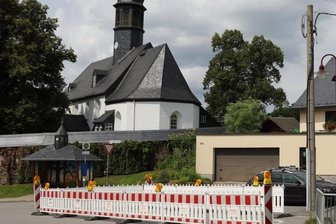 Kleine Absperrung bleibt Anwohnern lange erhalten - Diese Absperrung in Markersbach ist vorsorglich und wird lange stehen, denn noch ist offen, wie der notwendige Bau des kaputten Bachdurchlasses finanziert wird.