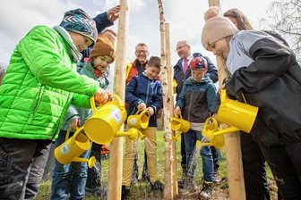 Kleine Gärtner gießen Baum des Jahres -