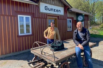 Kleiner Bahnhaltepunkt im oberen Vogtland wird weiter aufgewertet. - Christoph Kopp (hinten), Eigentümer des Gunzener Stationsgebäudes und Vorsitzender des Vereins Obervogtländische Eisenbahnen, und sein Stellvertreter Ingo Penzel mit einem historischen Gepäckkarren, der ursprünglich für die Badische Staatseisenbahn gebaut worden war.