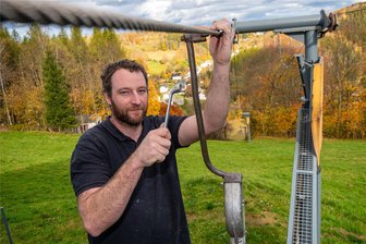 Klimawandel und Skifahren: Haben die vielen kleinen Lifte im Erzgebirge eine Zukunft? - Martin Schreiter überprüft am Mauersberger Lift „Am Bodenberg“ die Funktion einer Seilklemme am sogenannten Gehänge.