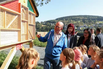 Klingenthal: Neues Parkplatz-Areal bietet auch Lebensraum für Bienen und Insekten - Berthold Löckelt, Vorsitzender vom Nabu-Regionalverband Vogtland und Initiator des Insektenhotels, erklärt den Schülern der Klasse 2a der Sigmund-Jähn-Grundschule, wer künftig in das Insektenhotel einziehen wird.