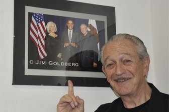 Klingenthaler Mundharmonikabauer wieder mit prominenten Musikern in den USA vertreten - Charlie Musselwhite vor einem Foto, das ihn mit dem früheren US-Präsidenten Barack Obama zeigt.