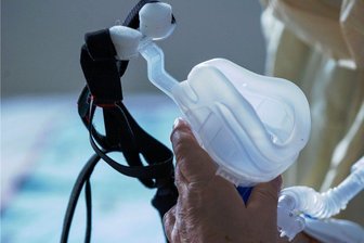 Kliniken im Erzgebirge behandeln immer mehr Corona-Patienten - Ein Covid-19-Patient hält eine Maske zur Beatmung in den Händen: Im Erzgebirgskreis ist die Anzahl der Patienten mit dem Virus in den Kliniken zuletzt wieder deutlich angestiegen. 