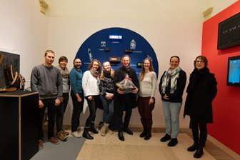 Knall und Konfettiregen im Schloss Augustusburg: Was war da los? - Konfetti-Knall und Präsent: Die Besuchergruppe aus Dresden, die das Kilometer-Rad-Jubiläum erdreht hat.
