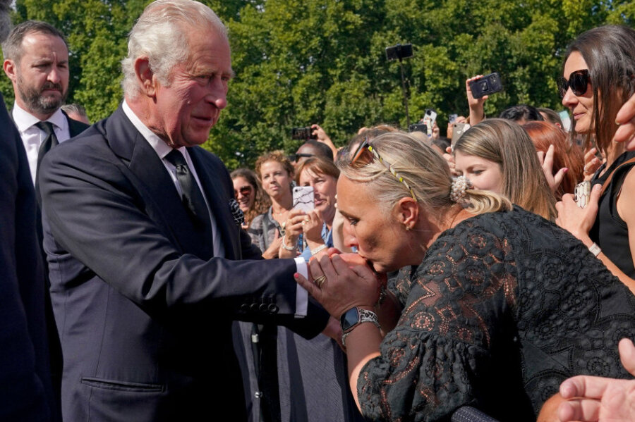 König Charles III. tritt in große Fußstapfen - Rundgang vor dem Buckingham-Palast in London: Eine Frau küsst die Hand von König Charles III. Der neue König war nach dem Tod von Elizabeth II. aus Schottland zurückgekehrt. 