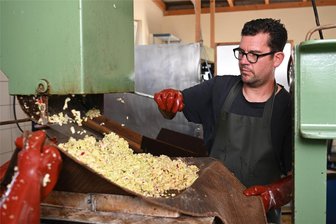 Königshain-Wiederau : Mosterei Stein presst trotz Ernteausfällen auch in diesem Jahr Saft aus heimischen Obst - In der Hofmosterei Stein bereitet Inhaber Markus Klitzsch die Maische zum Pressen vor.