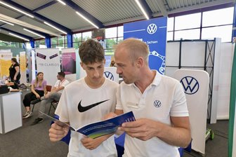 „Können gerade so die geforderten Plätze besetzen“: Wonach Jugendliche auf der Berufsmesse in Kirchberg suchen - Julian Richter (li.) im Gespräch mit Markus Pampel vom Bereich Berufsorientierung bei VW Sachsen.