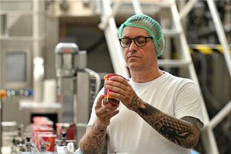Kohrener Landmolkerei aus Penig macht jetzt auch Bubble Tea - Ein Mitarbeiter prüft Bubble Tea, der in der sogenannten Becherlinie hergestellt wird. Pro Jahr können an der Linie maximal 30 Millionen Stück Becher abgefüllt werden.