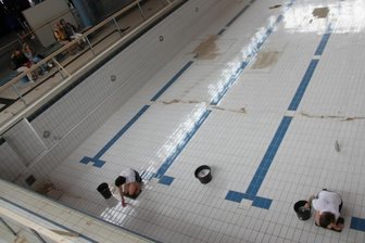 Kombination aus Verfall und Kunst erweist sich als Attraktion - Rachel Pursglove und Karolina Repp setzen auf Aktionskunst. Mit Zahnbürste und Lappen reinigen sie die Bodenfliesen des großen Schwimmerbeckens.