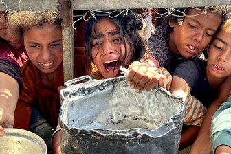 Kommentar zu Gewalt gegen Kinder in Konfliktgebieten: Die Schwächsten in der Schusslinie - Palästinensische Kinder versuchen im Gebiet Al-Mawasi im Gazastreifen, mit ihren Töpfen Nahrungsmittel zu bekommen, die von Wohltätigkeitsorganisationen verteilt werden.