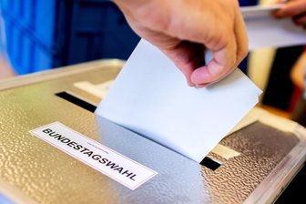 Kommentar zum AfD-Erfolg im Erzgebirge: CDU abgehängt, SPD am Boden - Was läuft schief? - Ein Wähler wirft seinen Stimmzettel für die Bundestagswahl in eine Urne. Im Erzgebirge liegt die AfD nach der Auszählung bei den Erst- und Zweitstimmen klar vorn.