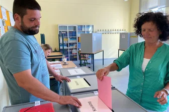 Kommunalwahl im nördlichen Vogtland: In Reichenbach liegt die AfD vorn - Stimmabgabe am Reichenbacher Kirchplatz. Ute Stier gibt am späteren Nachmittag ihren Stimmzettel für die Kreistagswahl auf die Reise. Alessandro Perthel vom Wahlvorstand bilanzierte zu diesem Zeitpunkt mit Schriftführerin Alina Seifert für den Wahlbezirk 102 eine gute Wahlbeteiligung.